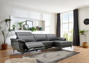 Graue Longchairkombination RONALD von XORA in einem modernen Wohnzimmer, seitliche Perspektive mit Blick auf das Sofa und die Fenster im Hintergrund.