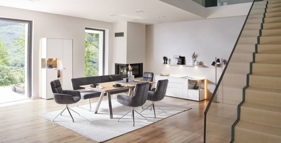 Esszimmer mit modernem Tisch und Stühlen in einem hellen Raum, seitliche Perspektive