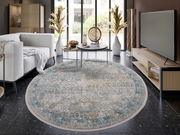 Runder Designer Teppich in einem modernen Wohnzimmer, mit einem eleganten Muster in Blau- und Beigetönen, aus der Vogelperspektive fotografiert.