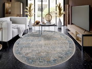 Runder Designer Teppich in einem modernen Wohnzimmer, mit einem eleganten Muster in Blau- und Beigetönen, aus der Vogelperspektive fotografiert.