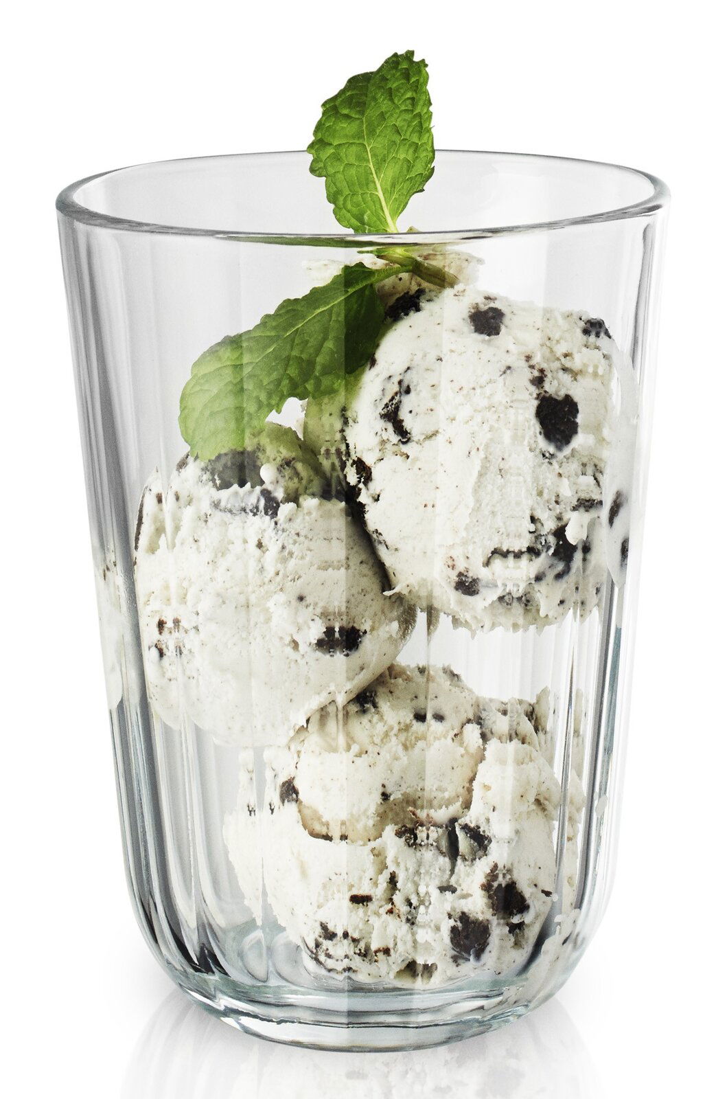Facettenglas mit 34 cl Fassungsvermögen, gefüllt mit drei Kugeln Cookies-and-Cream-Eis und dekoriert mit einem frischen Minzblatt, seitliche Perspektive.