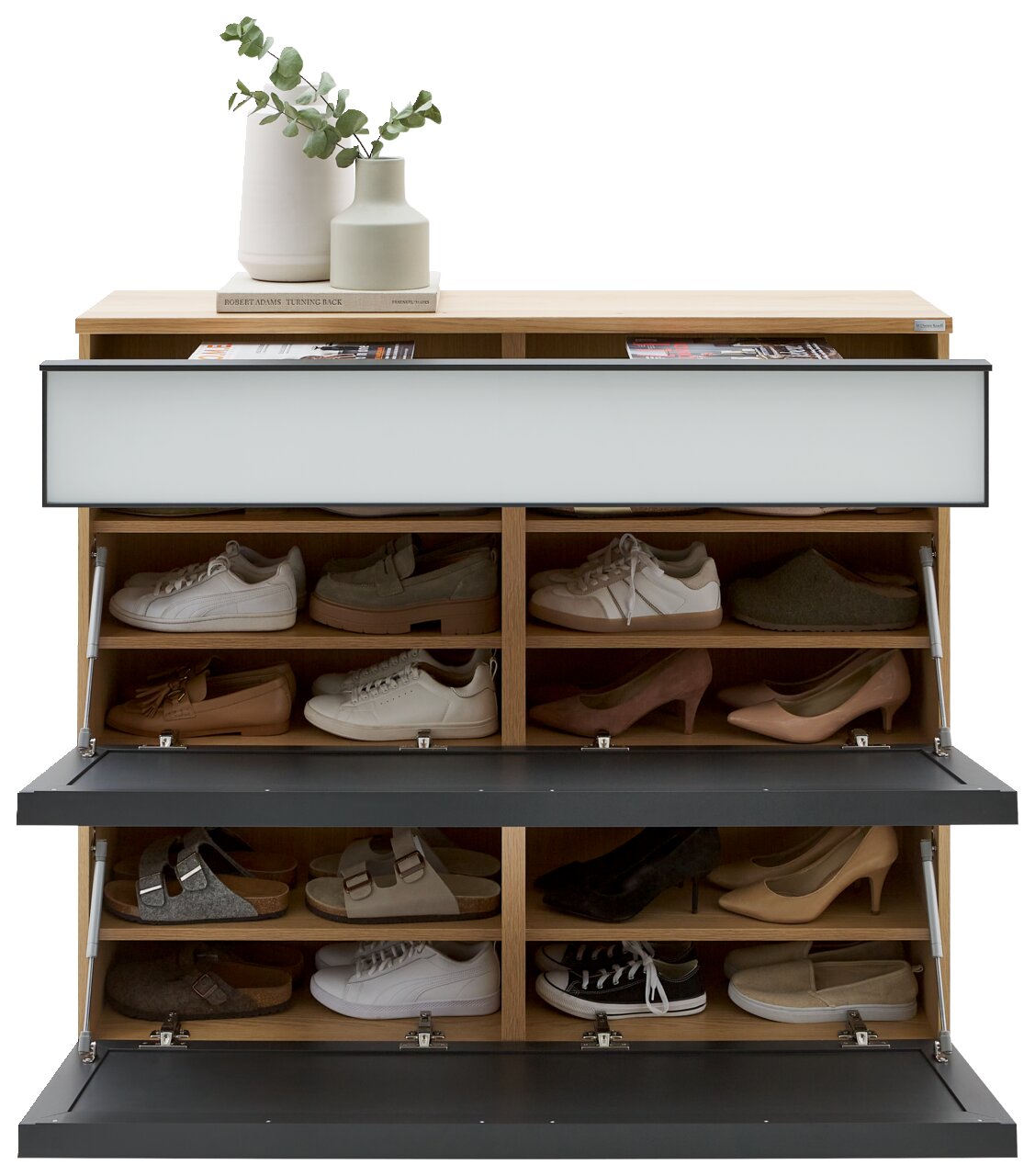 Schuhschrank aus Holz mit zwei nach vorn geöffneten Klappen in Anthrazit und mehreren Fächern, gefüllt mit Schuhen; oben Dekoration mit Vasen und Buch, Frontansicht.