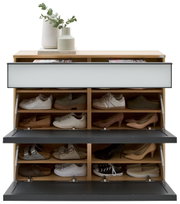 Houten schoenenkast met twee naar voren openende deuren in antraciet en verschillende vakken, gevuld met schoenen; bovenaan decoratie met vazen en een boek, vooraanzicht.