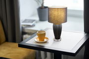 Tischleuchte IRINA von Globo Lighting auf einem Tisch neben einer Tasse Kaffee, seitliche Perspektive.