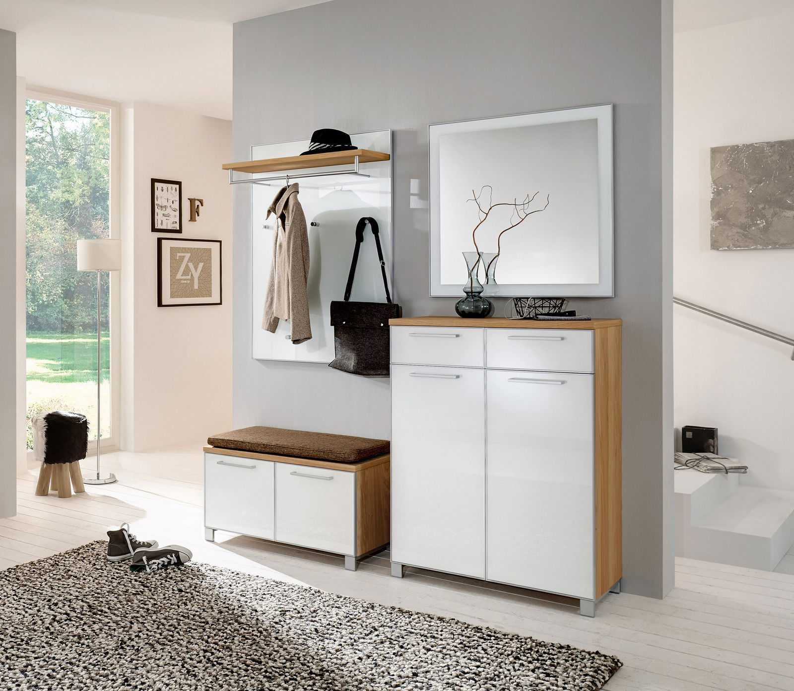 Moderne Garderobeneinrichtung mit weißem Hochglanz-Schuhschrank, Spiegel und Garderobenpaneel in einem hellen Raum. Perspektive von vorne.