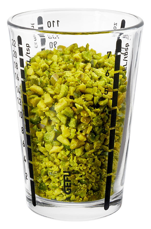 Mini Messbecher MESSI, 100 ml, gefüllt mit gehackten grünen Nüssen, seitliche Perspektive