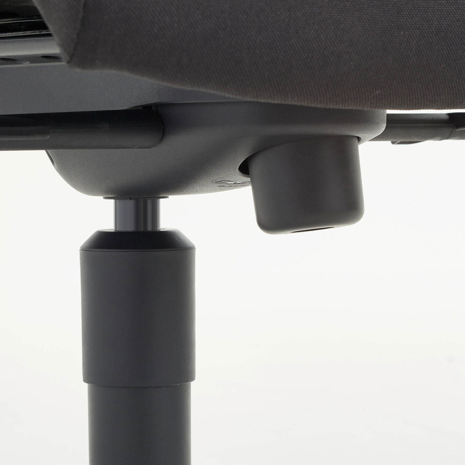 Nahaufnahme der Unterseite eines Chefsessels mit Fokus auf die Höhenverstellung.