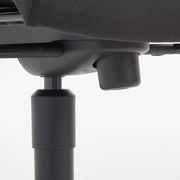 Nahaufnahme der Unterseite eines Chefsessels mit Fokus auf die Höhenverstellung.