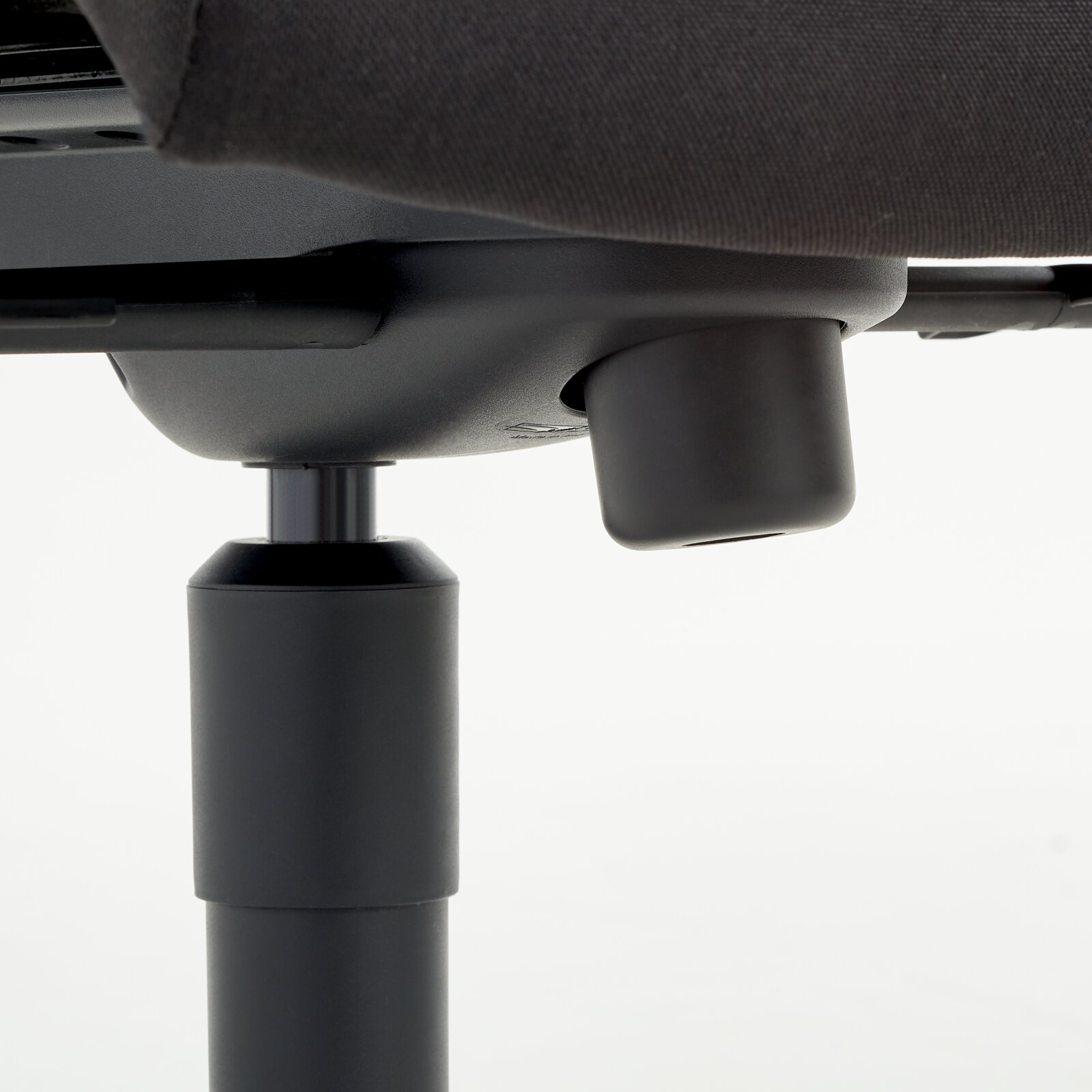 Nahaufnahme der Unterseite eines Chefsessels mit Fokus auf die Höhenverstellung.