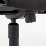 Close-up van de onderkant van een directiestoel, met de nadruk op de hoogteverstelling.