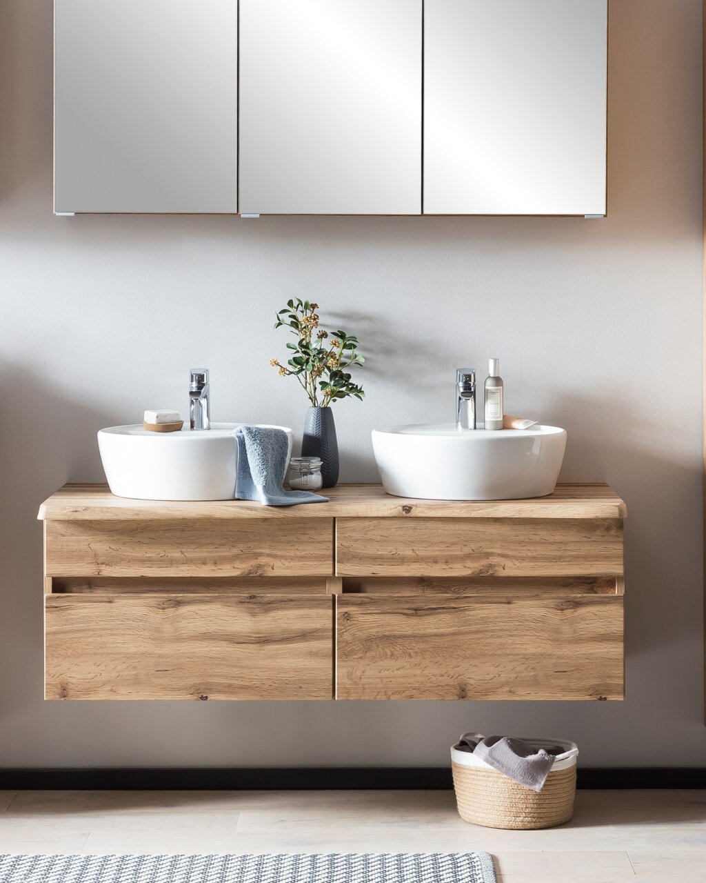 Moderne wastafelcombinatie met twee ronde wasbakken op een houten onderkast, gezien vanaf de voorkant.