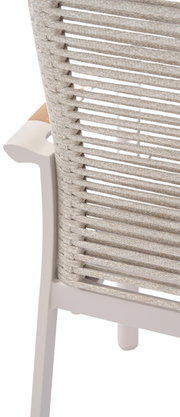 Achterkant van een stapelbare fauteuil met hoge rugleuning, een vlechtwerk van touw en lichte houten armleuningen.