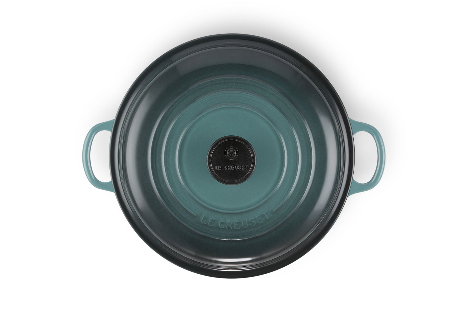 Obenansicht einer runden, türkisfarbenen Servierpfanne mit zwei Griffen und dem Schriftzug 'Le Creuset' in der Mitte.