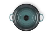 Obenansicht einer runden, türkisfarbenen Servierpfanne mit zwei Griffen und dem Schriftzug 'Le Creuset' in der Mitte.