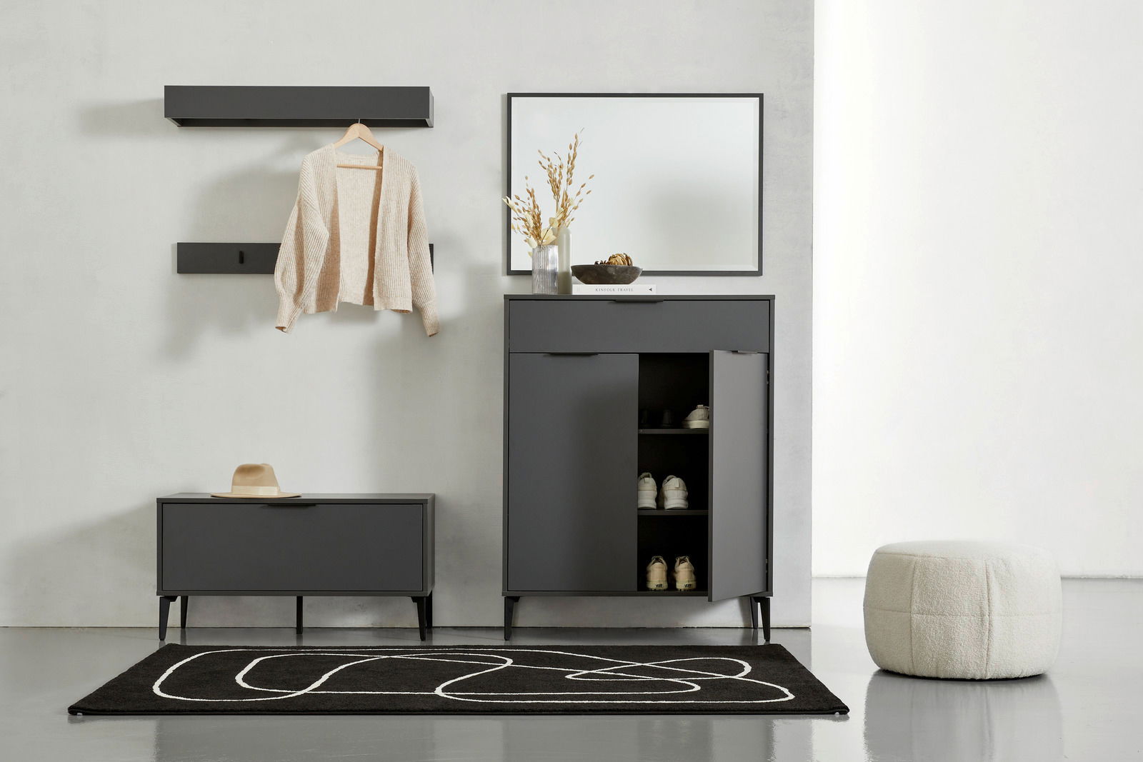 Moderne Garderobeneinrichtung mit Schuhschrank, Spiegel, Garderobenbank und Wandregalen in dunklem Design, frontal betrachtet.