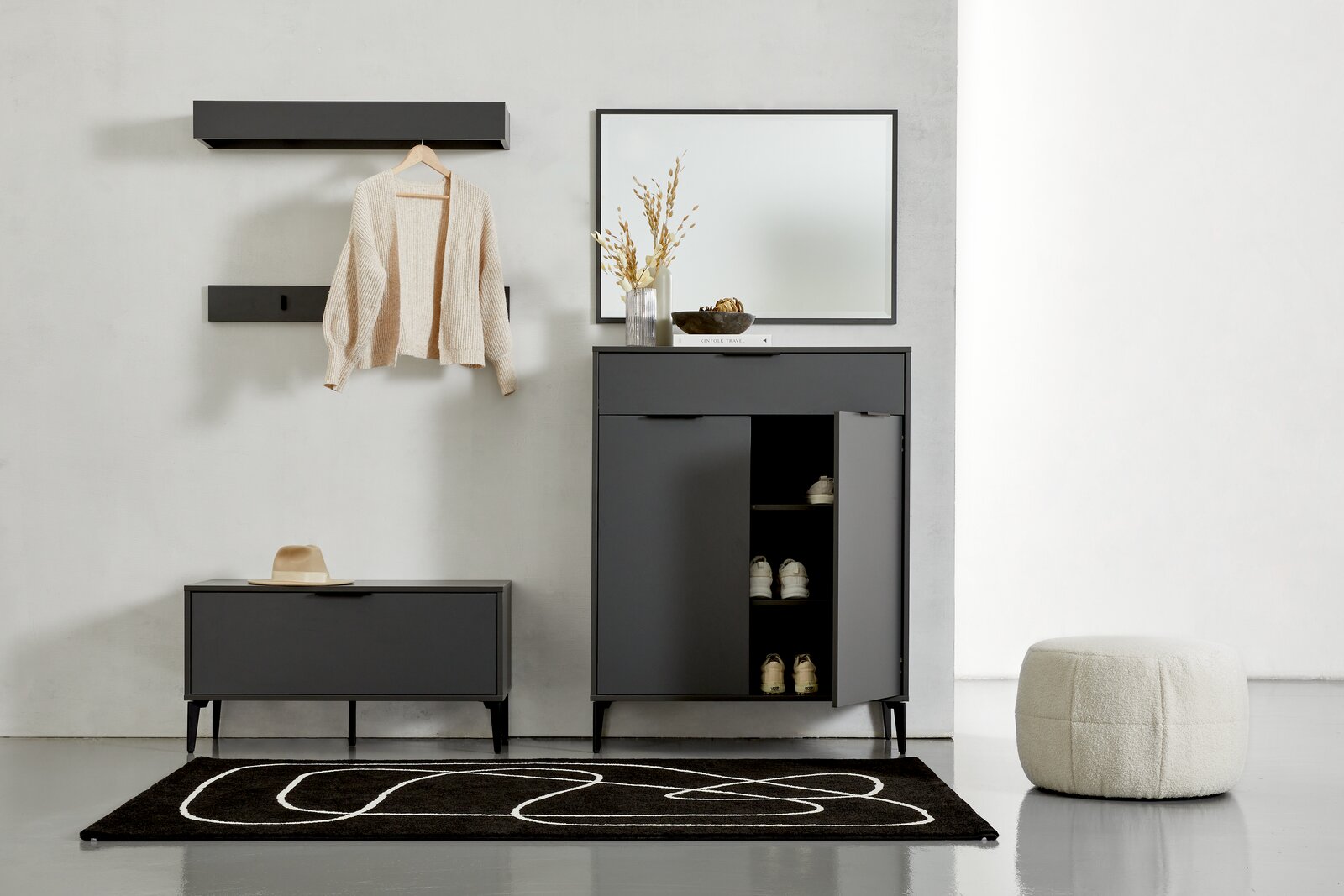 Moderne Garderobeneinrichtung mit Schuhschrank, Spiegel, Garderobenbank und Wandregalen in dunklem Design, frontal betrachtet.