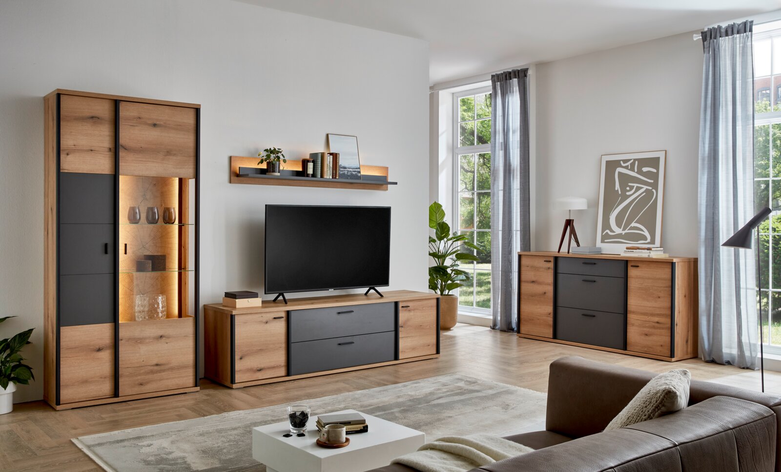 Modernes Wohnzimmer-Set aus Holz und Anthrazit mit Vitrine, TV-Lowboard, Sideboard und Wandregal; Perspektive: frontale Weitwinkelansicht im Raum.