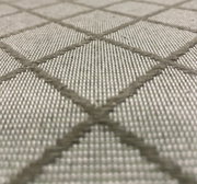 Close-up van een stofpatroon met een grijs ruitjespatroon, vanuit de zijkant in perspectief gefotografeerd.