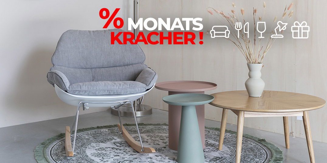 Gemütliche Sitzecke mit grauem Sessel, runden Tischen und Teppich, darüber Schriftzug „% MONATSKRACHER!