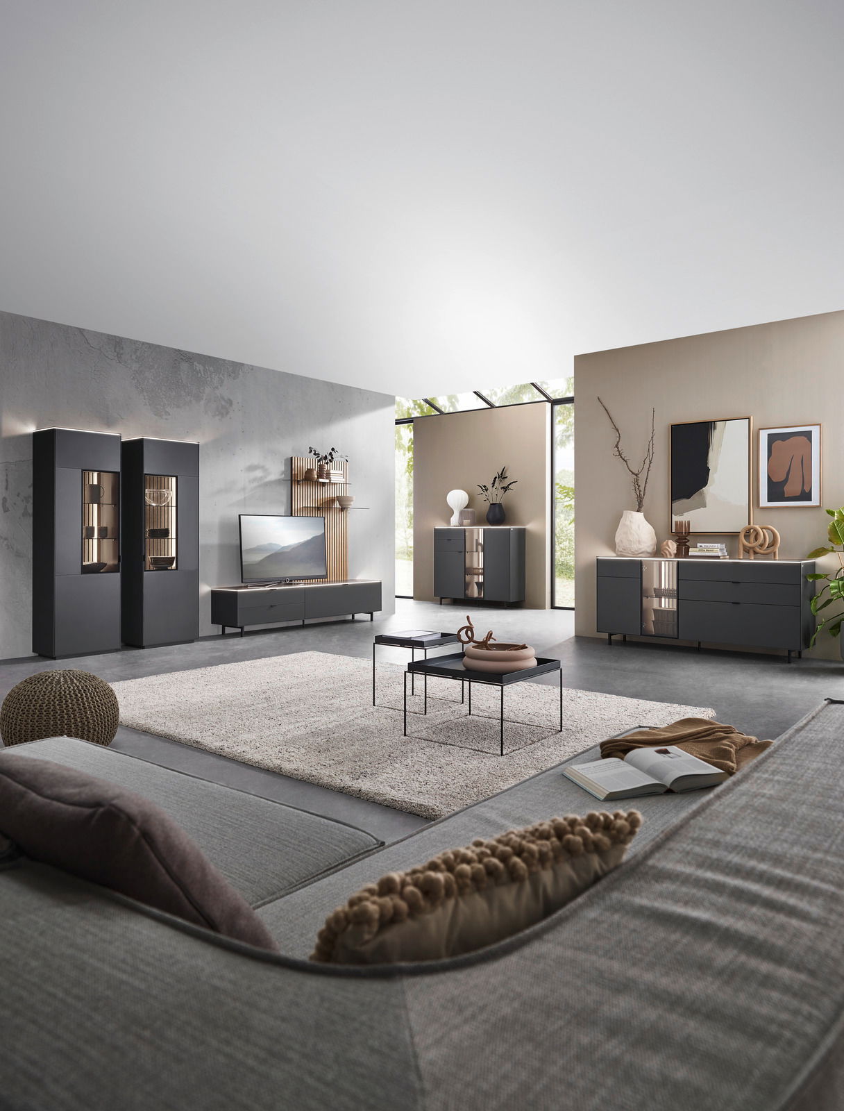 Dieter Knoll Highboard RIANI Moderne Wohnzimmermöbel in einem stilvollen Raum mit grauen Vitrinen, Sideboard und Highboard, Perspektive von der Sofaecke aus