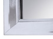 Nahaufnahme eines rechteckigen Spiegels mit silbernem Rahmen, Perspektive von der Ecke.