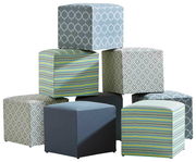 Sitzhocker in verschiedenen Mustern und Farben, gestapelt in einer pyramidenartigen Anordnung, seitliche Perspektive