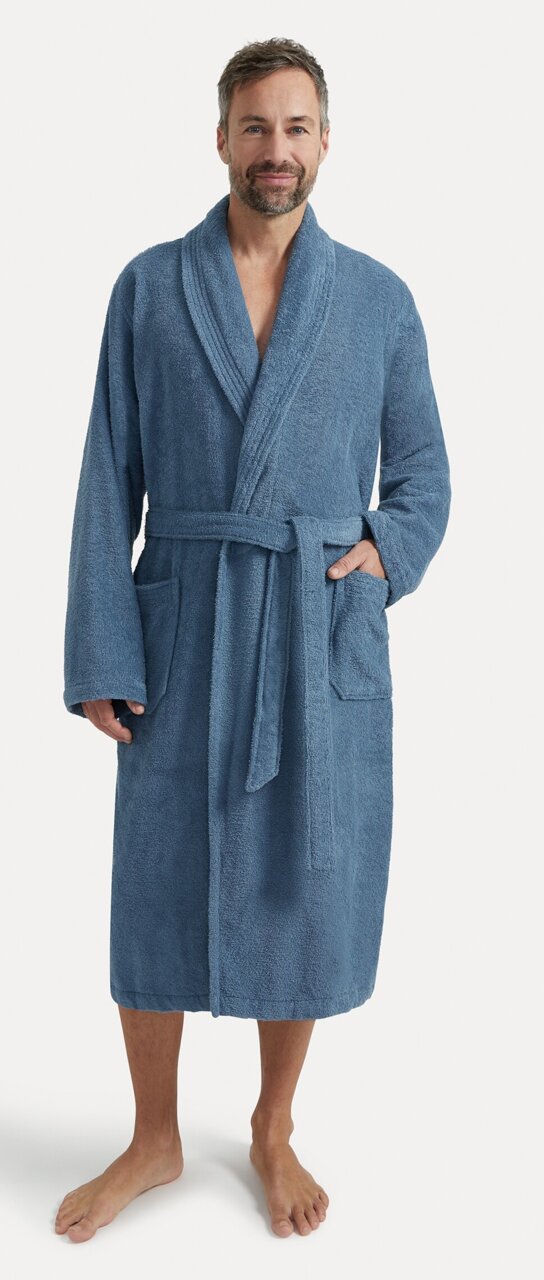 Mann in einem blauen Bademantel mit Schalkragen, stehend in Frontalansicht.