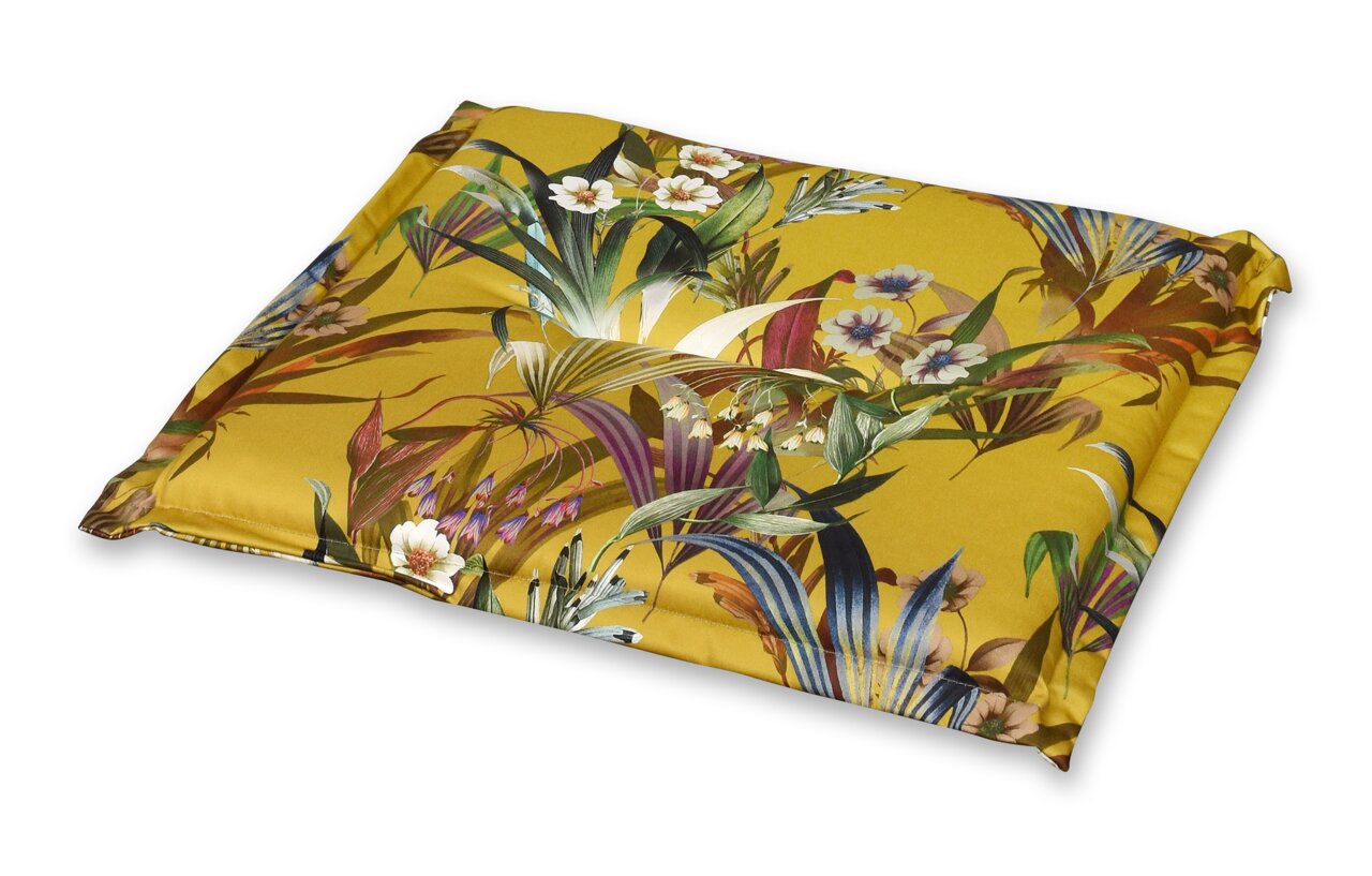 Hockerauflage mit tropischem Blumenmuster in Gelb, aus schräger Perspektive fotografiert.