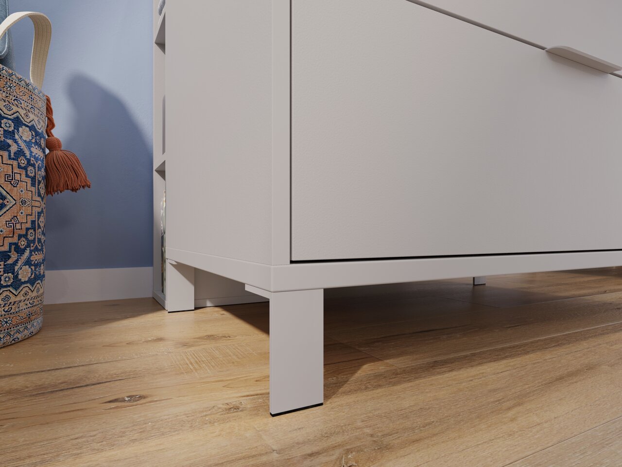 Nahaufnahme einer weißen, breiten Kommode auf Holzfußboden, seitliche Perspektive