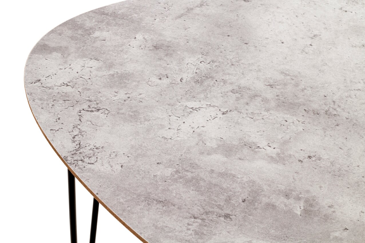 Detailaufnahme einer ovalen Tischplatte in grauer Stein-/Betonoptik mit sichtbarer Kante und schwarzen Metallbeinen, Perspektive schräg von oben