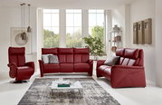 Rotes Ledersofa-Set bestehend aus einem Dreisitzer, einem Zweisitzer und einem Sessel in einem modernen Wohnzimmer mit großen Fenstern und stilvoller Dekoration, Frontalansicht.