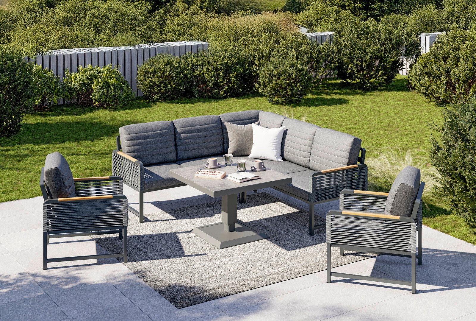 Moderne Loungegarnitur im Garten mit grauen Polstern, bestehend aus einem Ecksofa, zwei Sesseln und einem Tisch, aus der Vogelperspektive fotografiert.