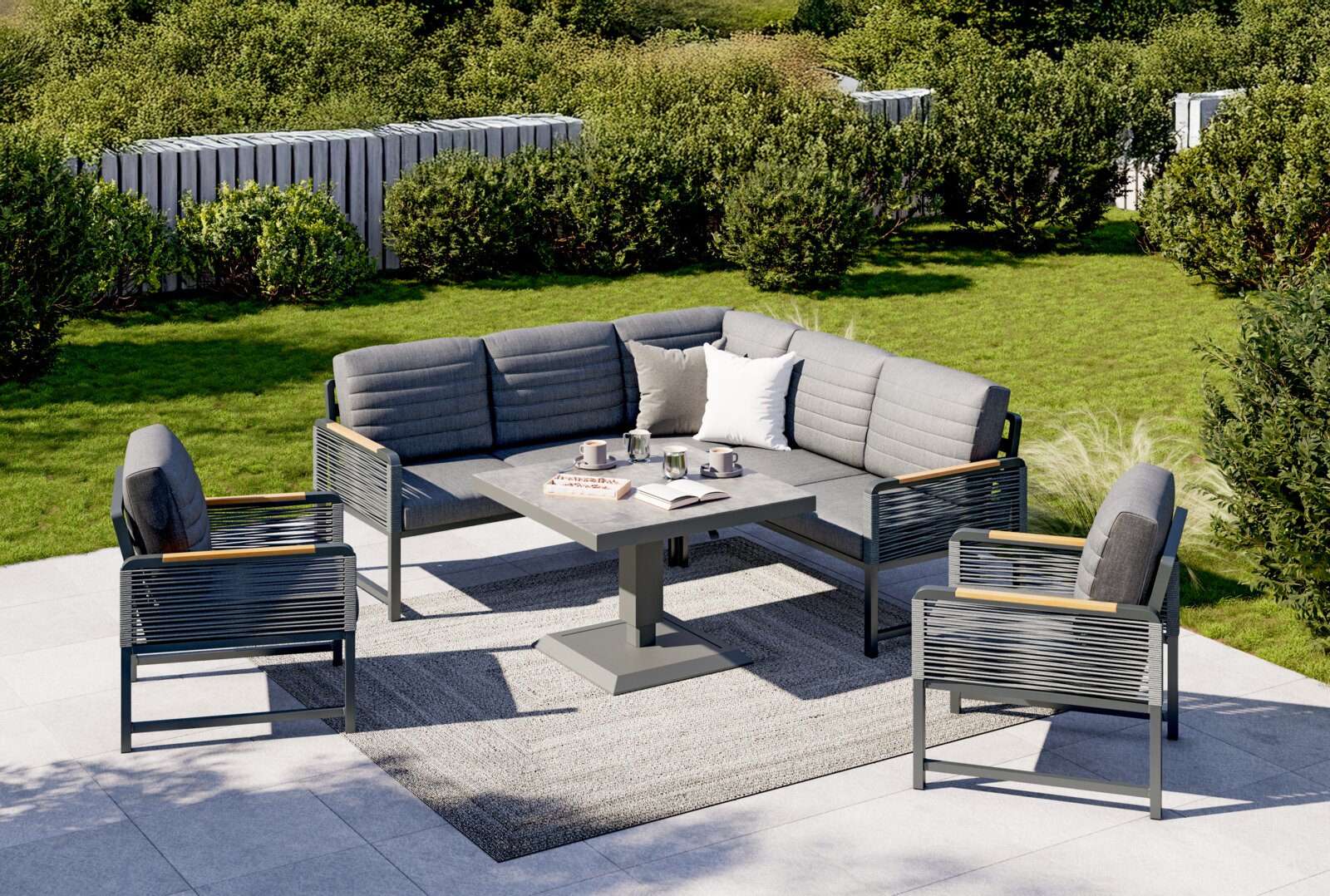 Moderne Loungegarnitur im Garten mit grauen Polstern, bestehend aus einem Ecksofa, zwei Sesseln und einem Tisch, aus der Vogelperspektive fotografiert.