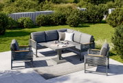 Moderne Loungegarnitur im Garten mit grauen Polstern, bestehend aus einem Ecksofa, zwei Sesseln und einem Tisch, aus der Vogelperspektive fotografiert.