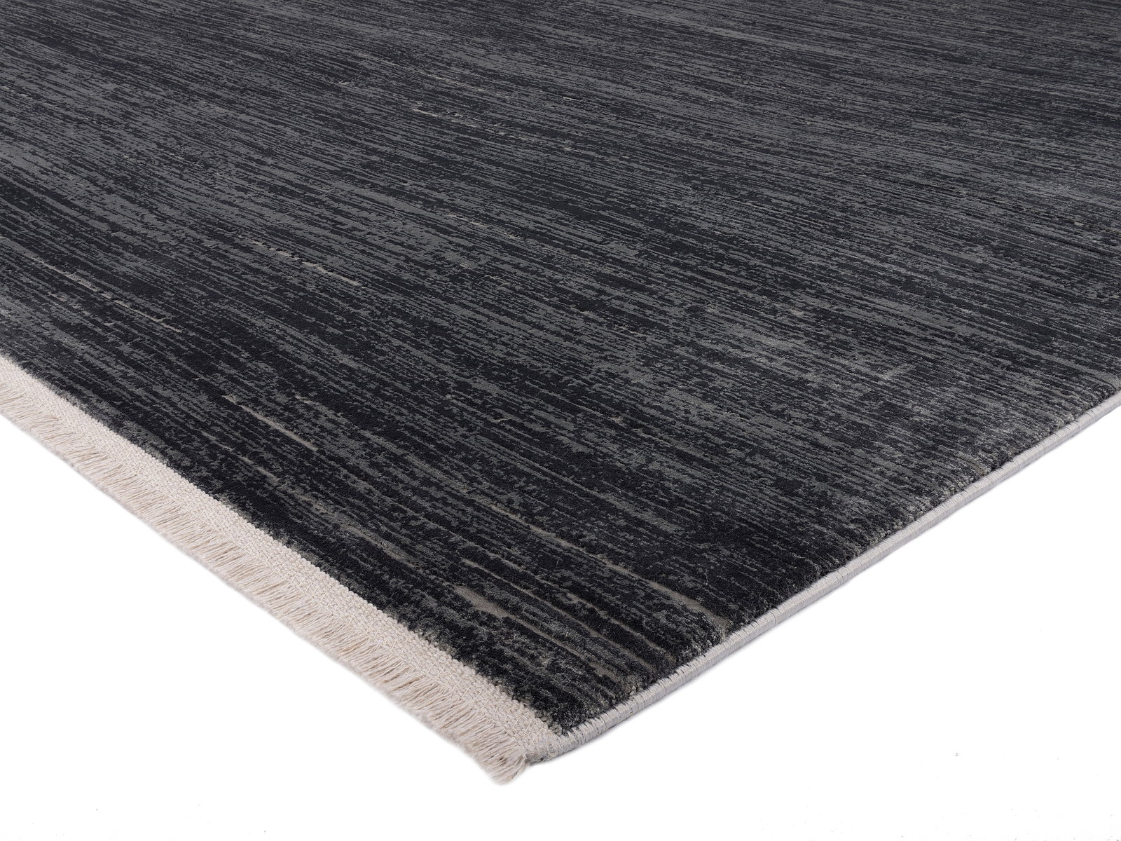 Designer Teppich in dunklen Grautönen mit heller Kante, perspektivisch von der Seite fotografiert