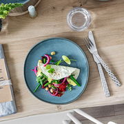 Frühstücksteller Lave 23,5 cm in Türkis, von oben fotografiert, mit einem dekorativen Gericht aus Gemüse und einem Omelett, auf einem Holztisch arrangiert.