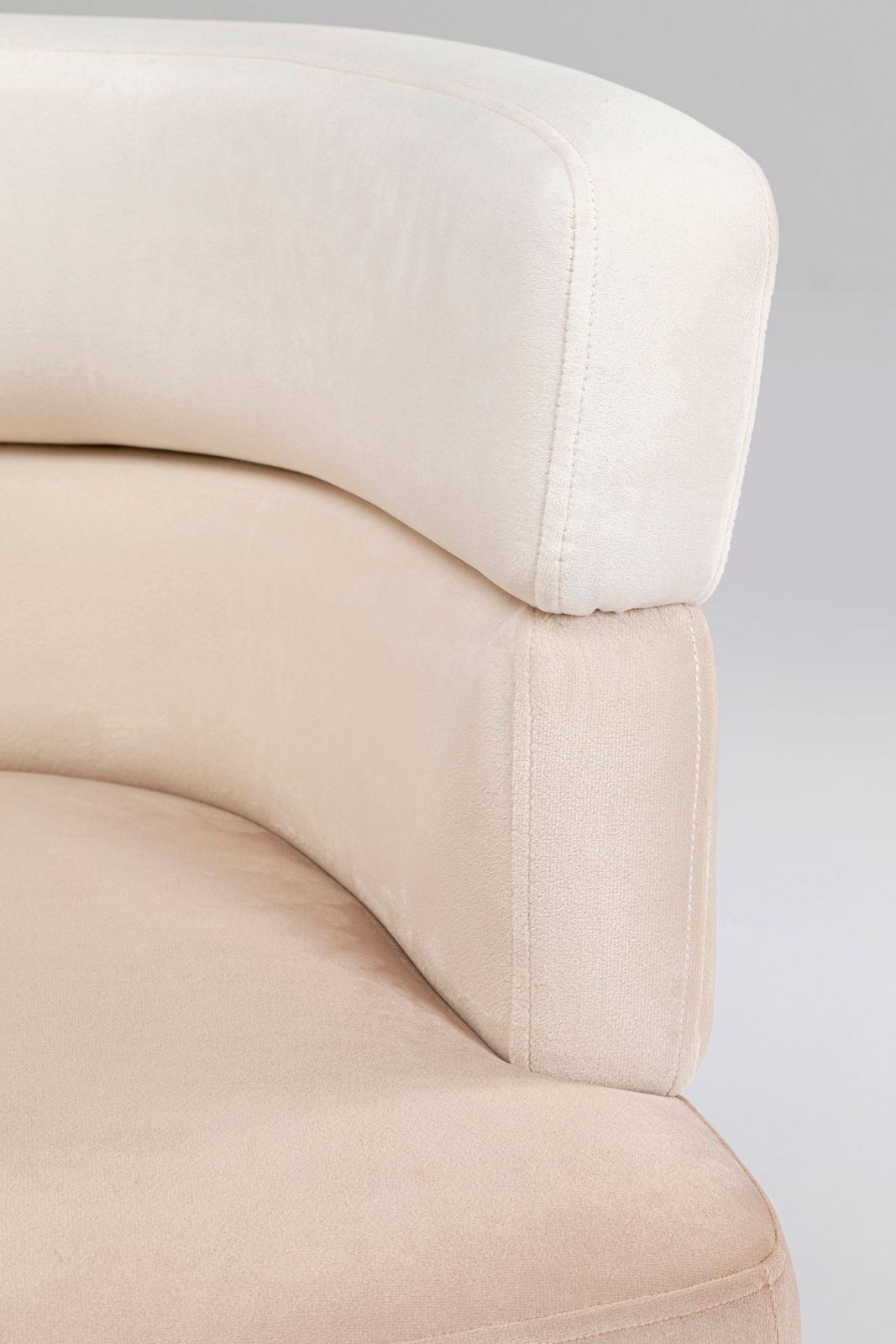 Nahaufnahme eines beigen Sessels mit weicher Polsterung, seitliche Perspektive