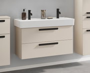Waschtisch-Set mit zwei Armaturen, cremefarbenem Unterschrank und schwarzen Griffen, seitliche Perspektive