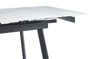 Detailansicht eines ausziehbaren Esstisches mit weißer Tischplatte und schwarzem Gestell, seitliche Perspektive