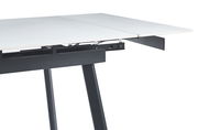 Detailansicht eines ausziehbaren Esstisches mit weißer Tischplatte und schwarzem Gestell, seitliche Perspektive