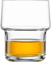 Transparant tumblerglas met dikke bodem en een laag amberkleurige drank, frontale close-up op witte achtergrond