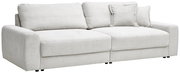 Großes, hellgraues Sofa mit geripptem Stoffbezug, zwei großen Sitzkissen und mehreren Rückenkissen, seitliche Perspektive