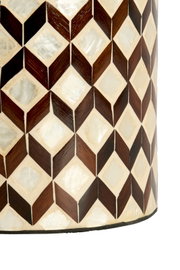 Nahaufnahme aus seitlicher Perspektive auf ein zylindrisches Wohnaccessoire mit geometrischem Würfelmuster aus dunklem Holz und schimmernden Perlmutt-Intarsien