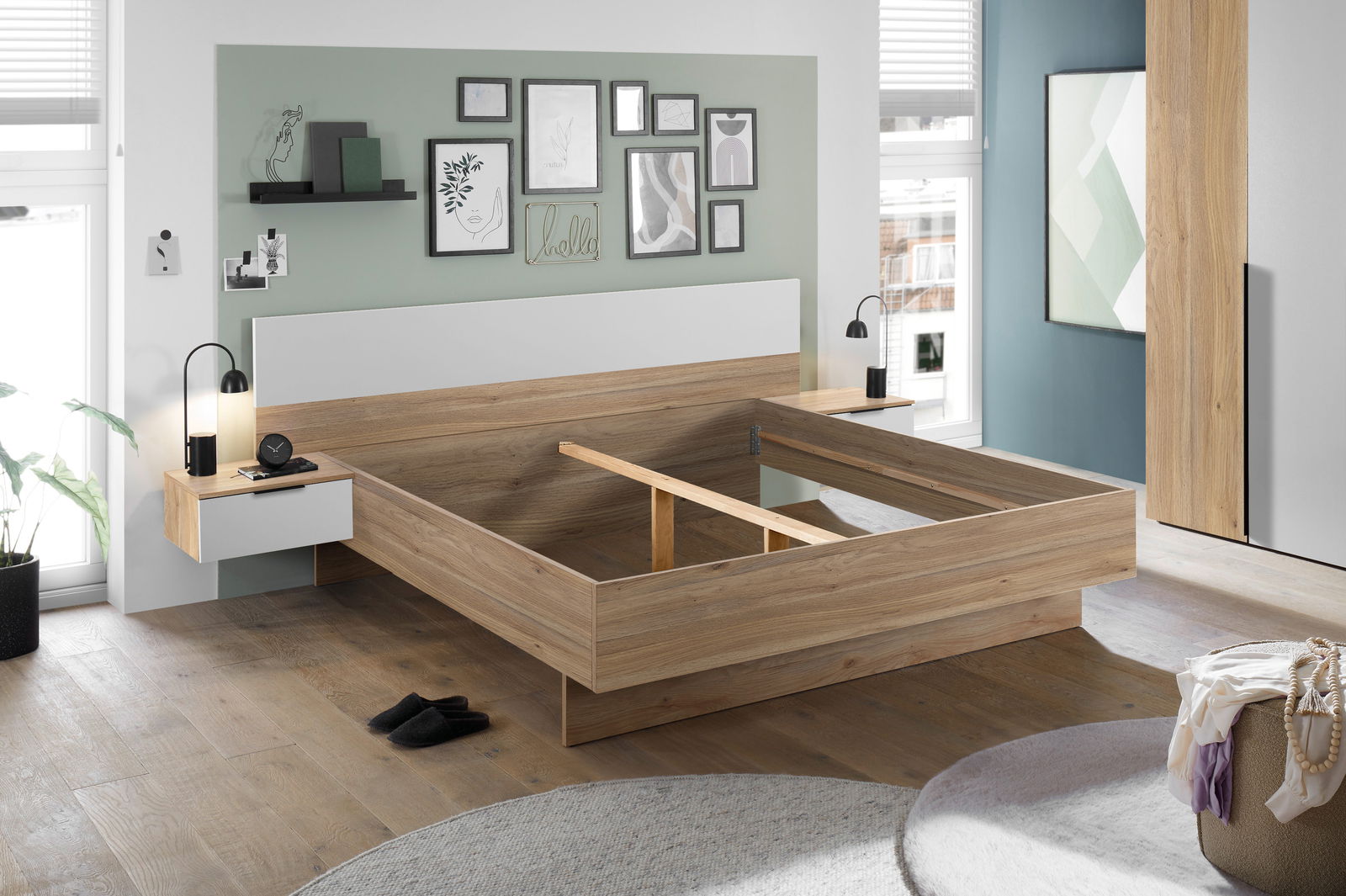 Modernes Schlafzimmer mit einem stilvollen Holzbettgestell, flankiert von zwei Nachttischen mit Lampen, in einer hellen und einladenden Umgebung. Perspektive von vorne links.