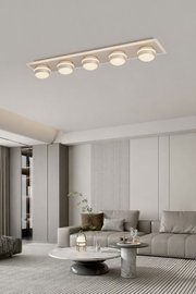 Moderne LED-Deckenleuchte mit fünf runden Leuchtelementen, von unten betrachtet in einem stilvollen Wohnzimmer.