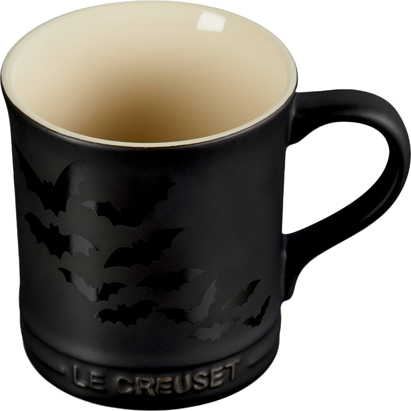 Schwarze Le Creuset Tasse mit cremefarbener Innenseite und glänzendem Fledermausmotiv, schräg von vorn und oben mit Henkel rechts dargestellt
