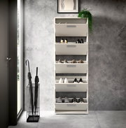 Schuhkipper mit fünf Fächern, frontal fotografiert, gefüllt mit verschiedenen Schuhen, in einem modernen Raum mit grauer Wand und Regenschirmständer.