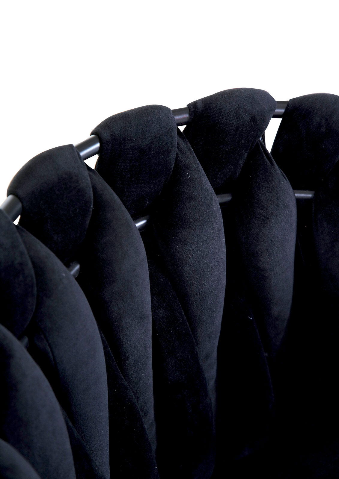 Nahaufnahme eines schwarzen Sessels mit gepolsterten, geflochtenen Elementen und Metallrahmen, von oben betrachtet.