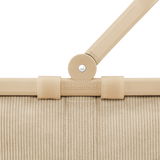 Nahaufnahme des oberen Teils eines sandfarbenen Carrybags mit Griff und Strukturmuster, von vorne betrachtet.