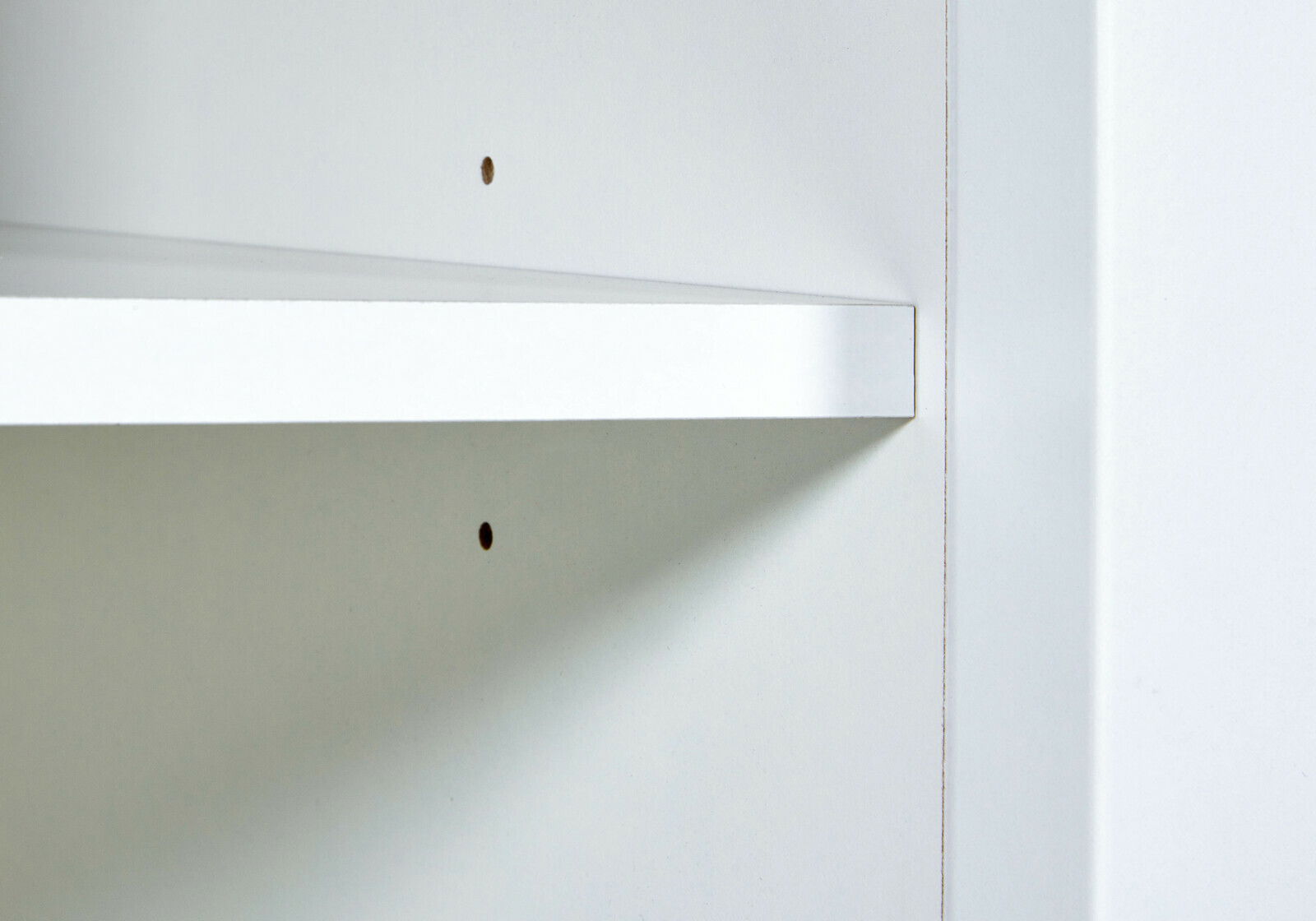 Nahaufnahme eines weißen Standregals mit verstellbaren Einlegeböden, seitliche Perspektive